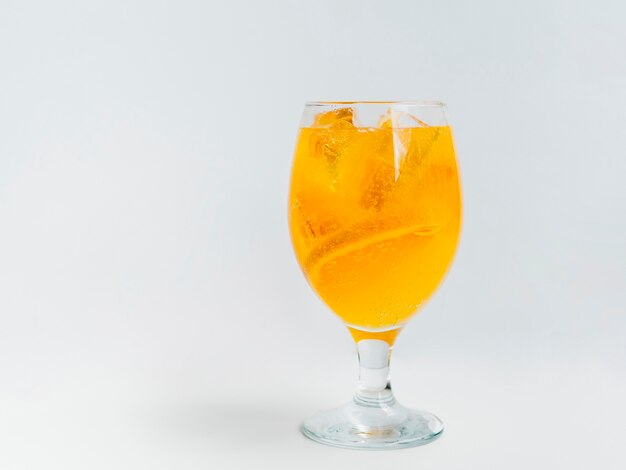 Sparkling cocktail with orange slices and ice cubes