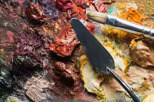 Free photo spatula and brush on blots of paint