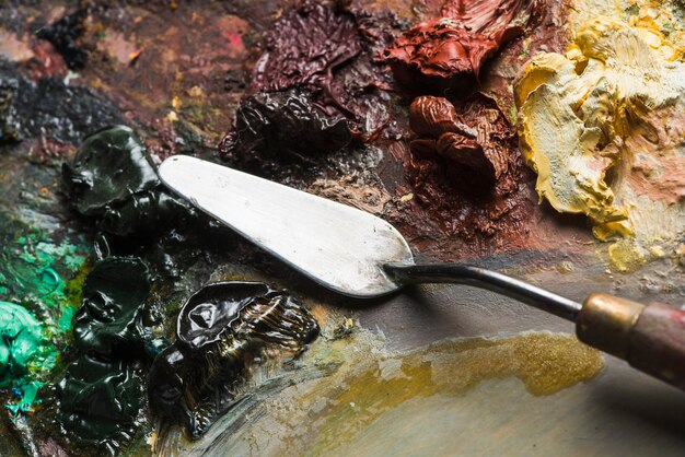 Spatula mixing paint on palette