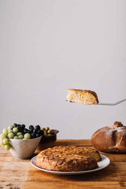 Spatula with cake over table with food