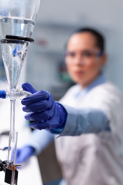 전문 생물학 도구를 사용하여 생화학 실험에서 일하는 전문 화학자 여성