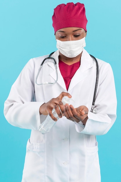 Medico femminile specialista utilizzando disinfettante per le mani