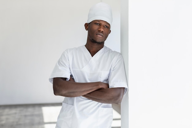 Free photo specialist male doctor leaning on a white wall