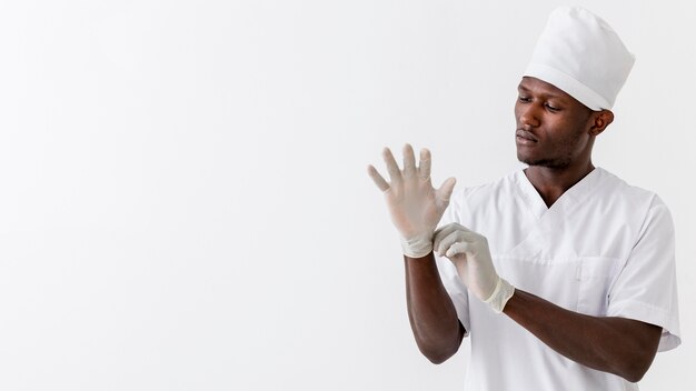 Specialist male doctor puts the medical gloves