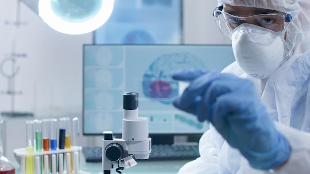 Free photo specialist researcher holding microscope slide analyzing blood sample working at coronavirus vaccine development during virus examination in microbiology hospital laboratory. biochemistry experiment