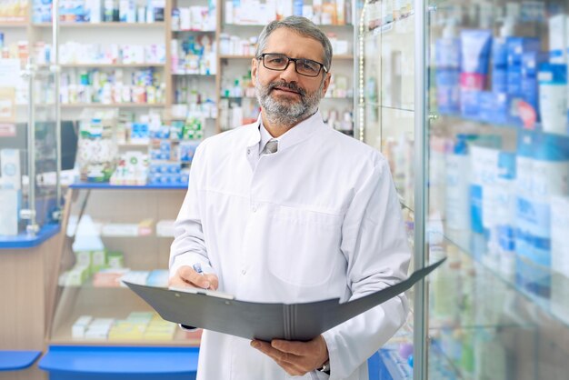 Specialist standing in drugstore holding folder