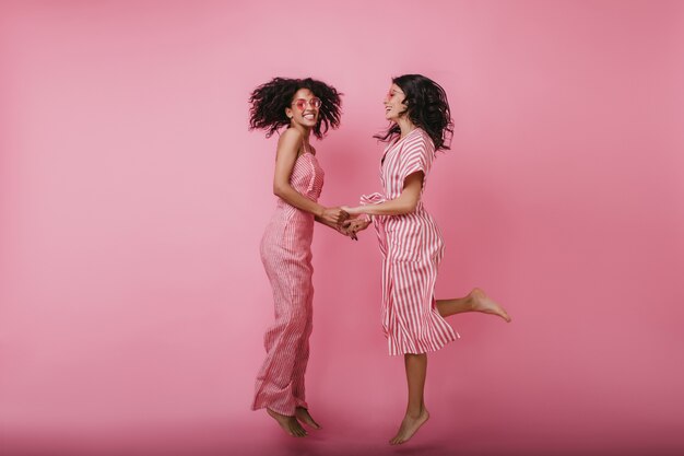 手をつないで見てかわいい女友達 うれしそうなアフリカの女の子とヨーロッパのブルネットの女性 無料の写真 手をつないで見てかわいい女友達 うれしそうなアフリカの女の子とヨーロッパのブルネットの女性 無料の写真