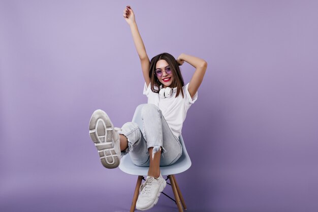 Spectacular happy lady in headphones having fun. Indoor shot of pretty caucasian female model fooling around.