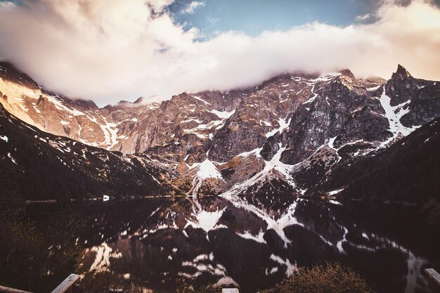 Spectacular view to the beautiful mountains with mirroed reflection and clouds at sunrise time.