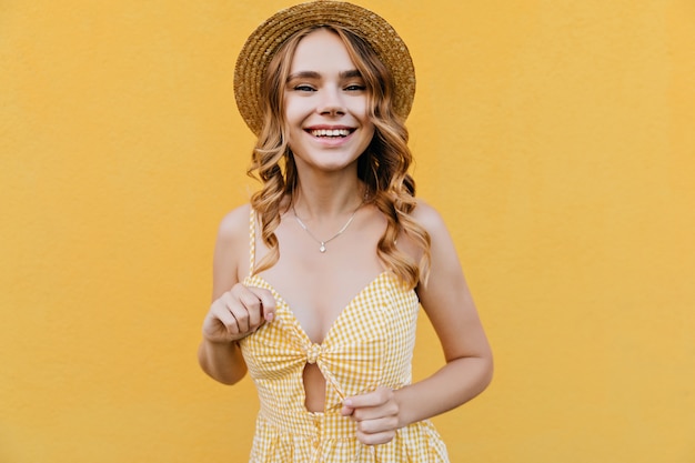 Spettacolare ragazza bianca in abito alla moda che esprime emozioni positive. foto dell'interno della signora adorabile isolata nel cappello.