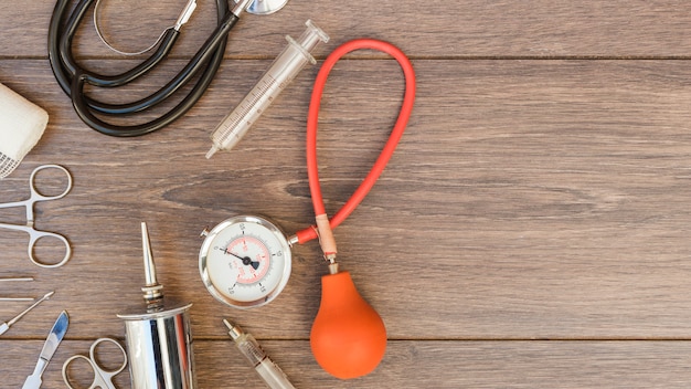 Sphygmomanometer; stethoscope and medical equipment's on wooden desk