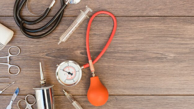 Sphygmomanometer; stethoscope and medical equipment's on wooden desk