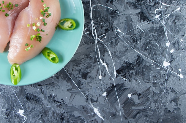 Бесплатное фото Чаши для специй и куриная грудка на тарелке, на мраморном фоне.