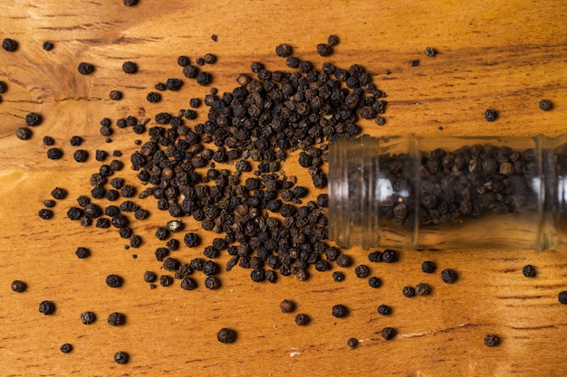 Spices. Jar and heap of pepper on the table