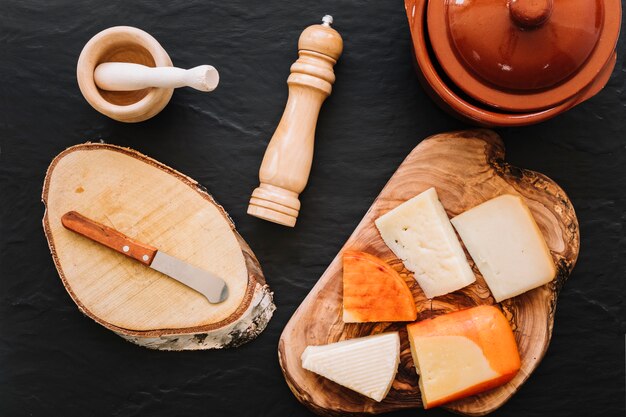 Spices and knife near cheese and pot