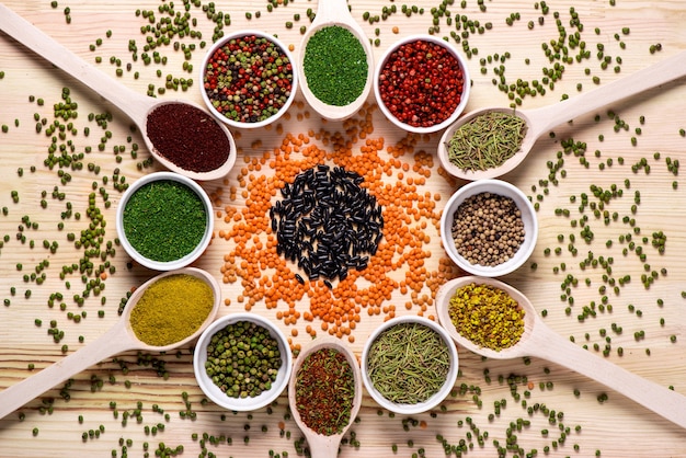 Spices in spoons on wooden table