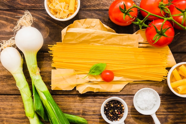 Spices and vegetables around spaghetti