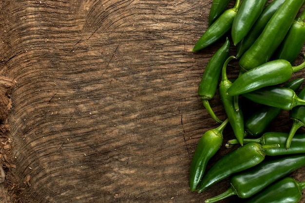 Foto gratuita peperone verde piccante su fondo di legno