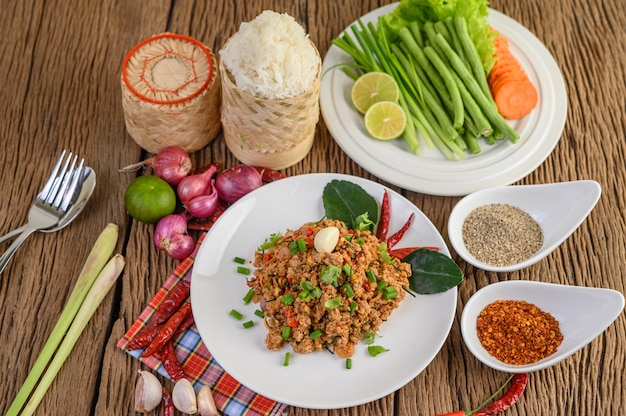 Spicy minced pork on a white plate and sticky rice box