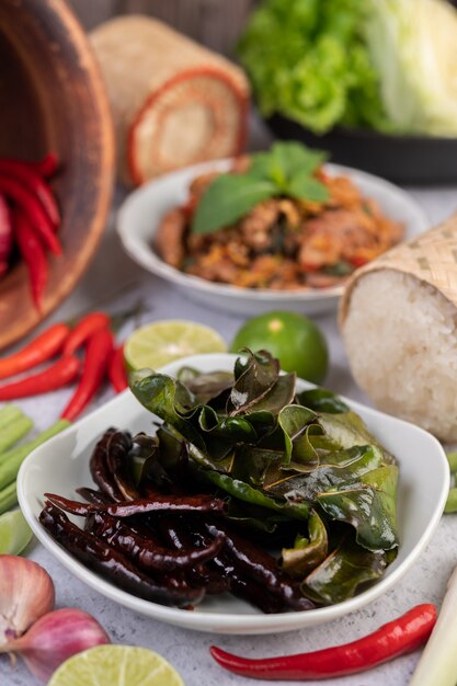 Spicy pork chops in a white dish consisting of lemons, chilies, and side dishes. Selective focus.