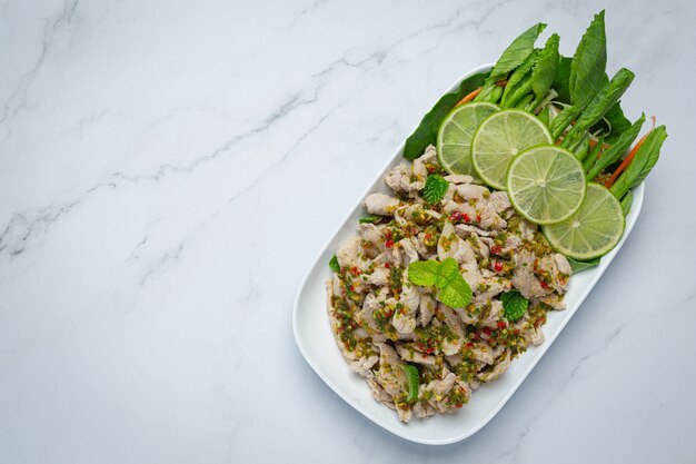 スパイシーポークサラダ新鮮なクリスピーケールの茎タイ料理を添えて。
