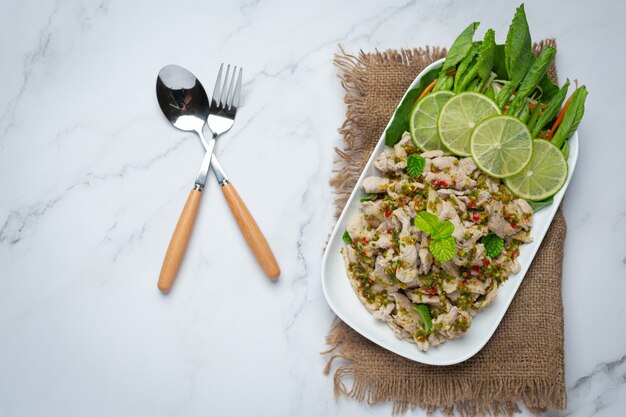 Острый салат из свинины Подается со свежими хрустящими стеблями капусты. Тайская кухня.