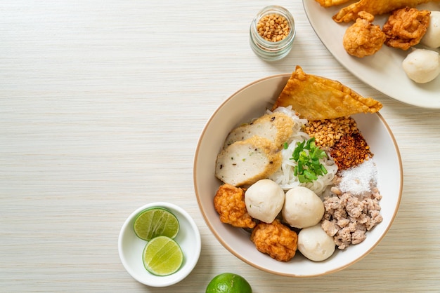 Острая маленькая плоская рисовая лапша с рыбными шариками и шариками из креветок без супа - азиатский стиль еды