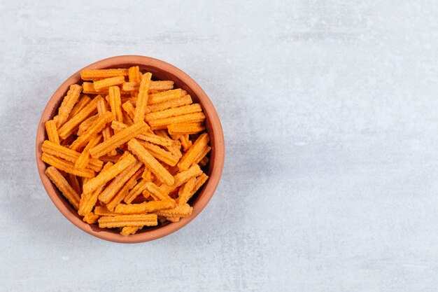 Spicy stick chips in ceramic bowl.