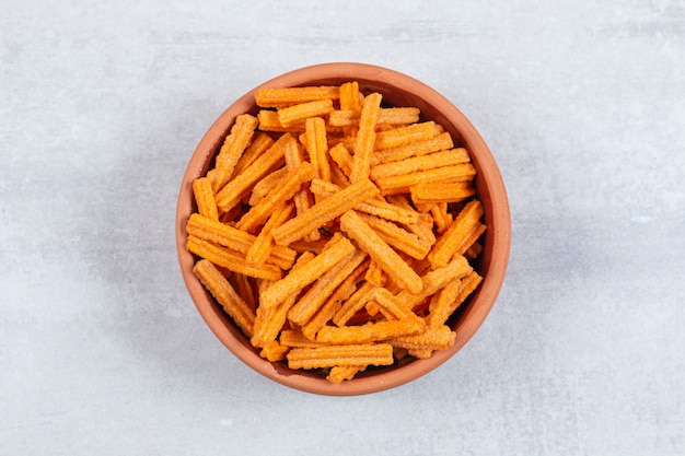 Spicy stick chips in ceramic bowl.