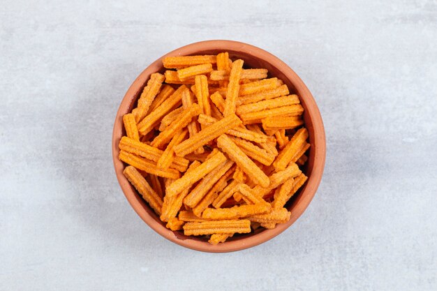 Spicy stick chips in ceramic bowl.