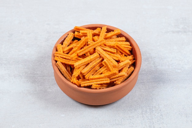 Spicy stick chips in ceramic bowl.