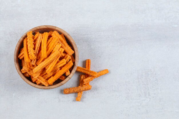 Spicy stick chips in wooden bowl.