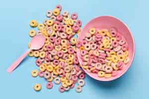 Free photo spilled cereal fruit loops from a pink bowl