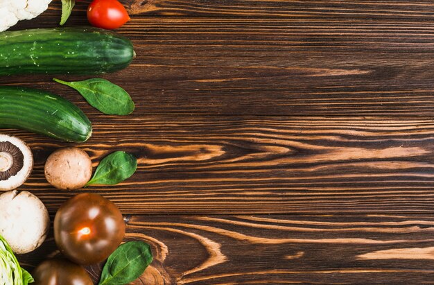 Spinach and vegetables on wooden tabletop