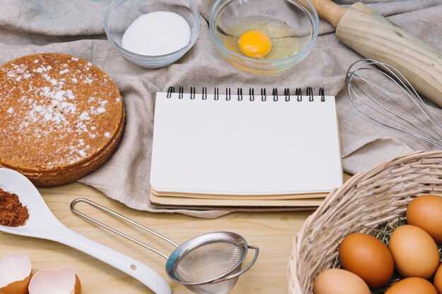 材料とケーキを作るためのツールとスパイラル空白のメモ帳