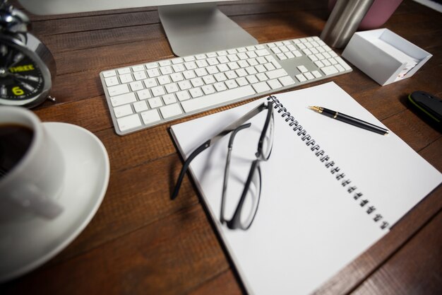 Spiral notepad with black coffee and spectacle