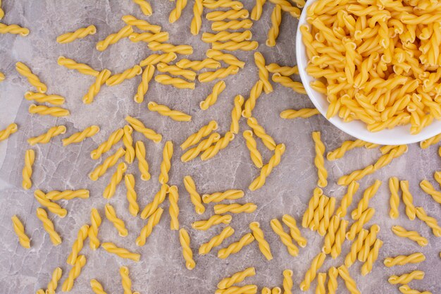 Spiral pasta in a white ceramic plate on the marble