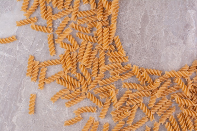 Free photo spiral shape pastas isolated on the marble space.