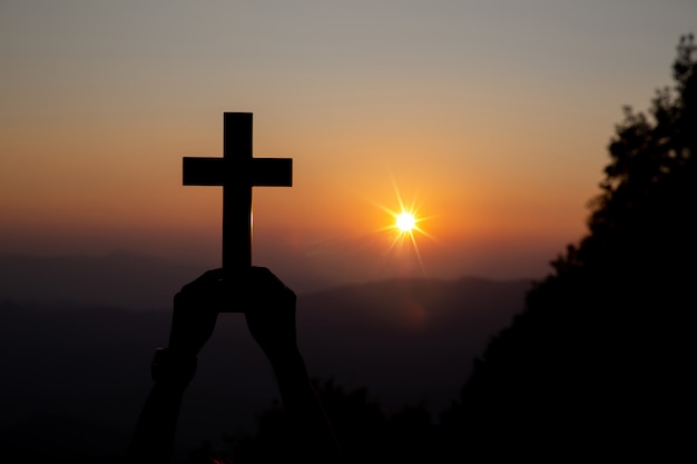 太陽の上の精神的な祈りの手がぼやけて美しい夕日と輝き