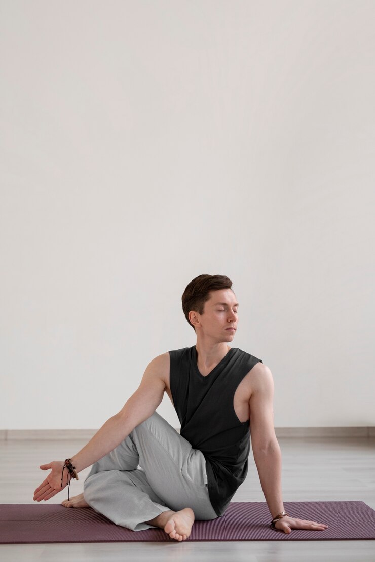 Free Photo spiritual young man practicing yoga indoors
