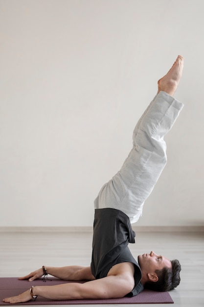 Spiritual young man practicing yoga indoors