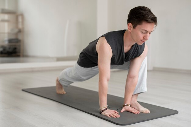 Spiritual young man practicing yoga in sportswear