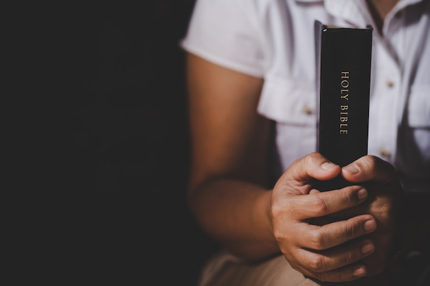 Foto gratuita spiritualità e religione, mani giunte in preghiera su una sacra bibbia in concetto di chiesa per fede.