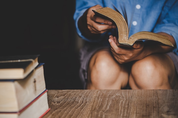 Free photo spirituality and religion, hands folded in prayer on a holy bible in church concept for faith.