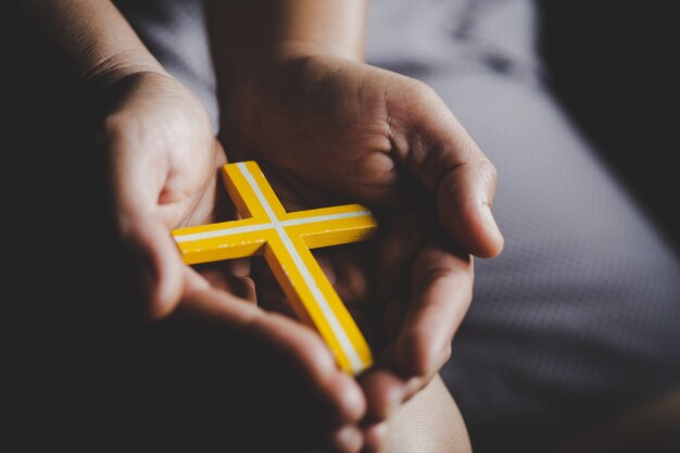 Spirituality and religion,Women in religious concepts Hands praying to God while holding the cross symbol. Nun caught the cross in his hand. 