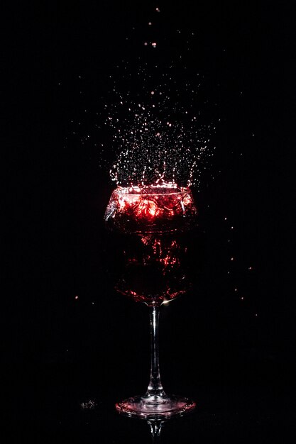 Splashes of wine fly around crystal glass