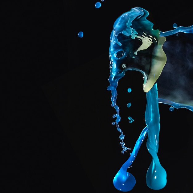 Splashing colorful liquids on black background