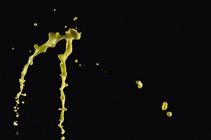 Free Photo splashing yellow paint on black background