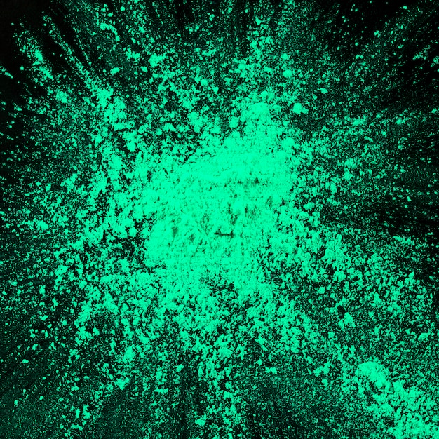 Free photo splatted turquoise holi powder against black background