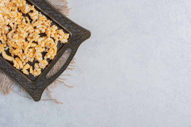 Free photo splintered biscuit cake on an ornate tray on marble surface